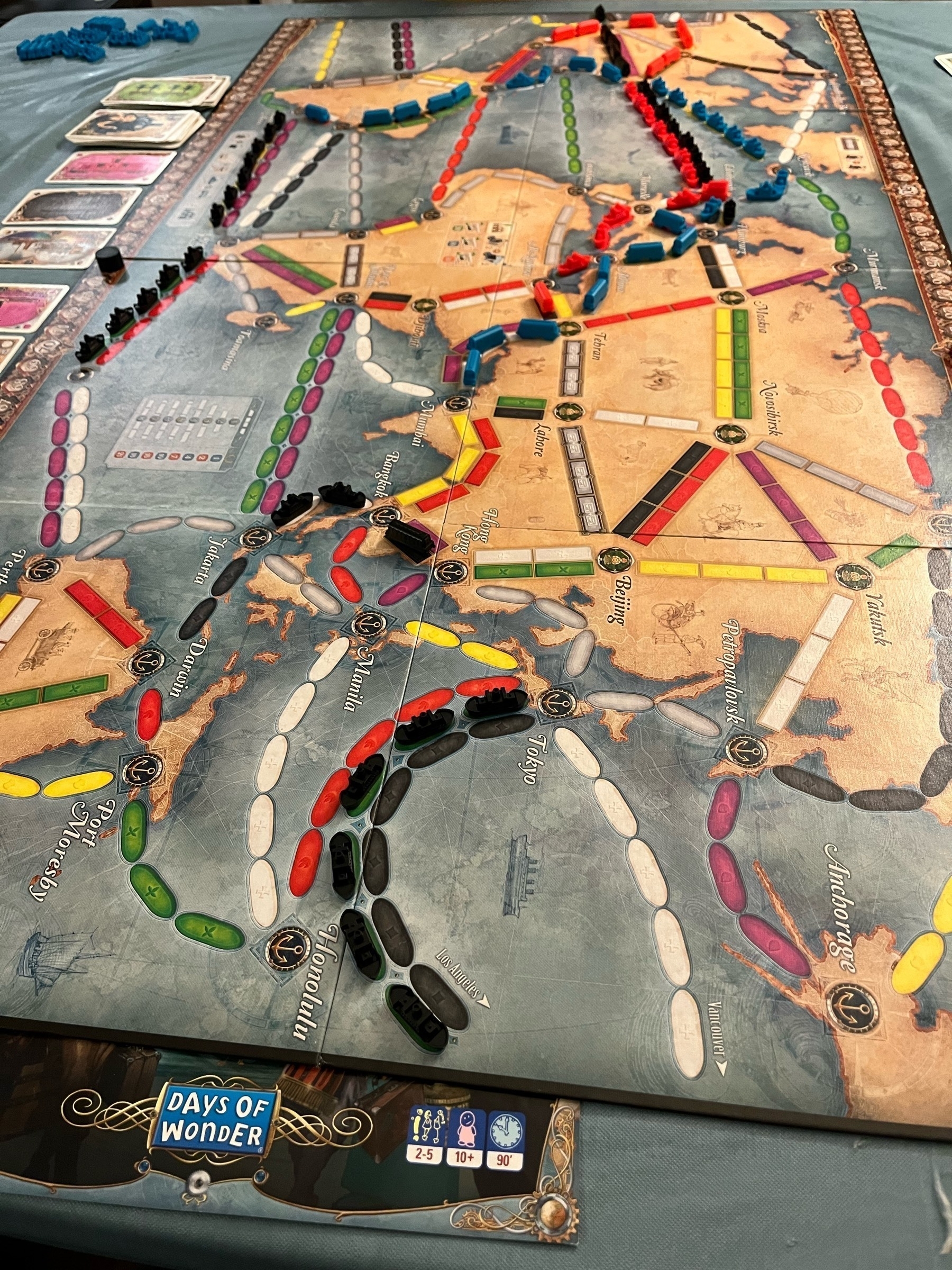 Ticket to Ride Rails and Sails game board with the color game pieces and game cards on the table. 