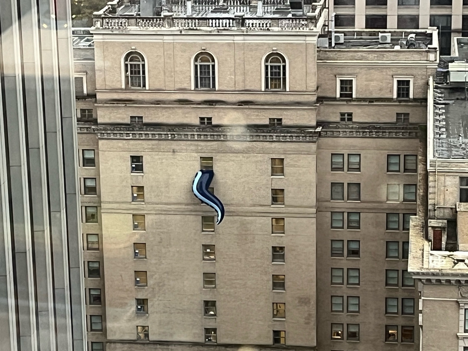 Side of the Fairmont Olympic Hotel in Seattle with a big tentacle sticking out of a window. 